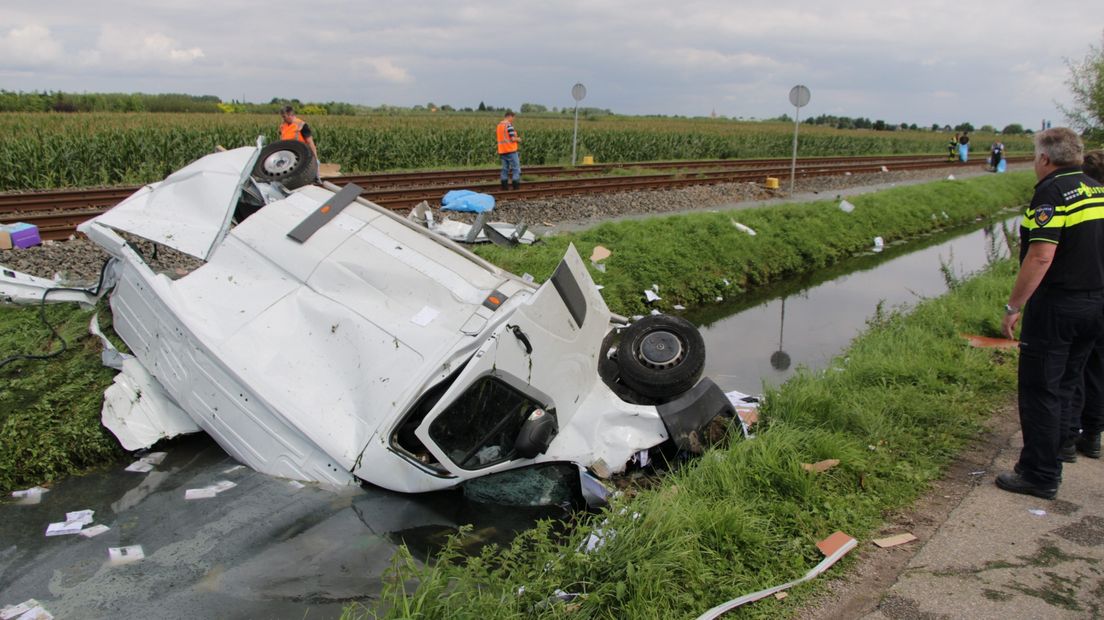 Bij een onbewaakte spoorwegovergang in Opheusden is vrijdagmiddag een koeriersbusje met een trein in botsing gekomen. De bus sloeg over de kop en belandde in de sloot. Een persoon raakte gewond, maar was wel aanspreekbaar.