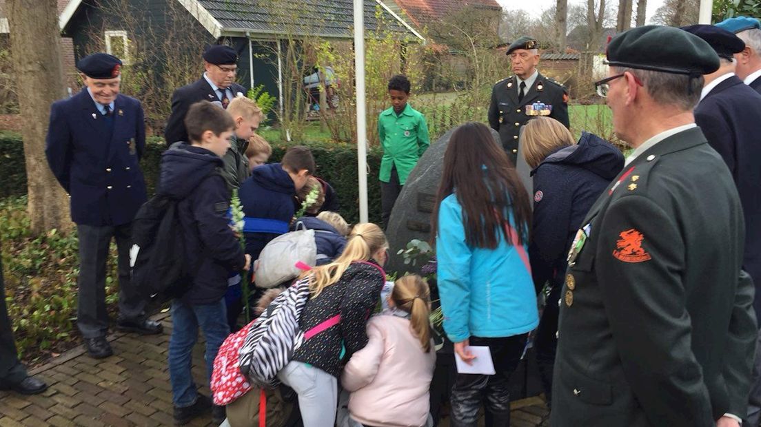 Leerlingen leggen bloemen bij het monument