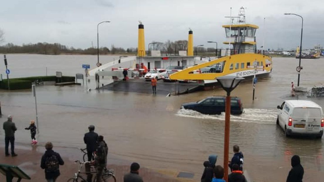 Auto's rijden door het water om bij de pont in Schoonhoven te komen