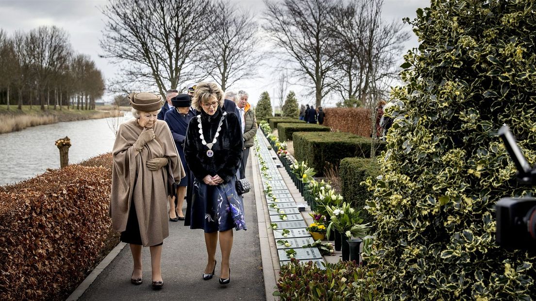 Prinses Beatrix loopt met de burgemeester langs de graven van slachtoffers uit Oude-Tonge