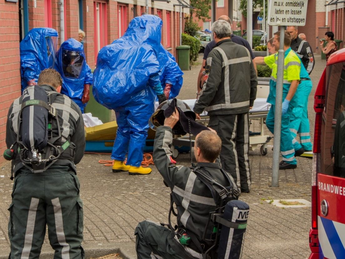 Brandweerlieden in speciale pakken voor het huis aan het Klipperpad