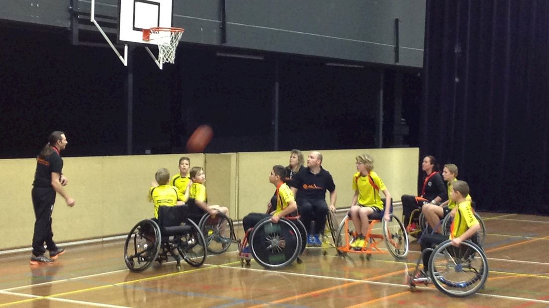 De leerlingen spelen samen met leden van de Stichting Rolstoelbasketbal een partijtje