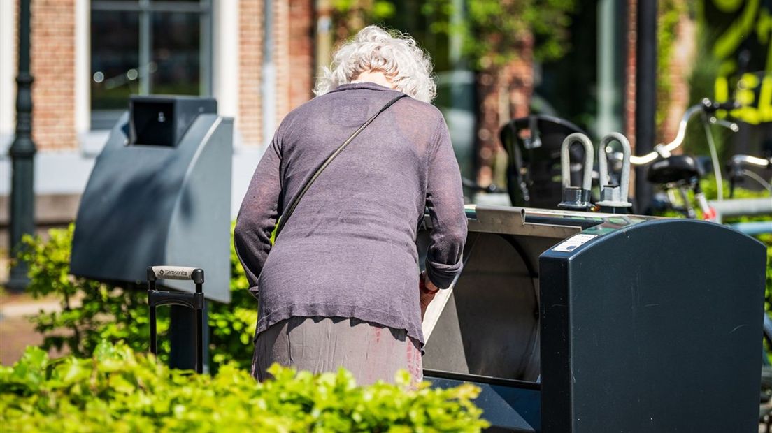 Een vrouw gooit afval in een ondergrondse container in Zwolle