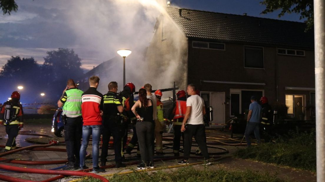 Buurtbewoners zien hoe de brandweer het vuur onder controle krijgt