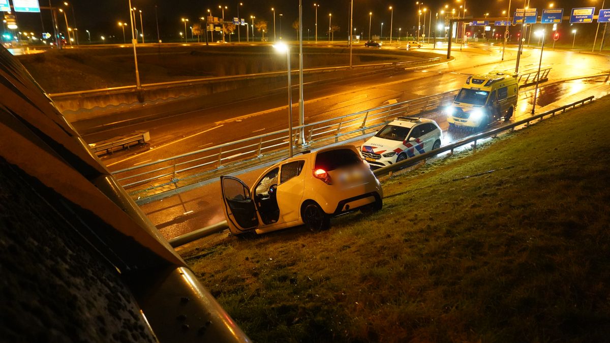 Automobilist ramt verkeersbord en schiet van talud af