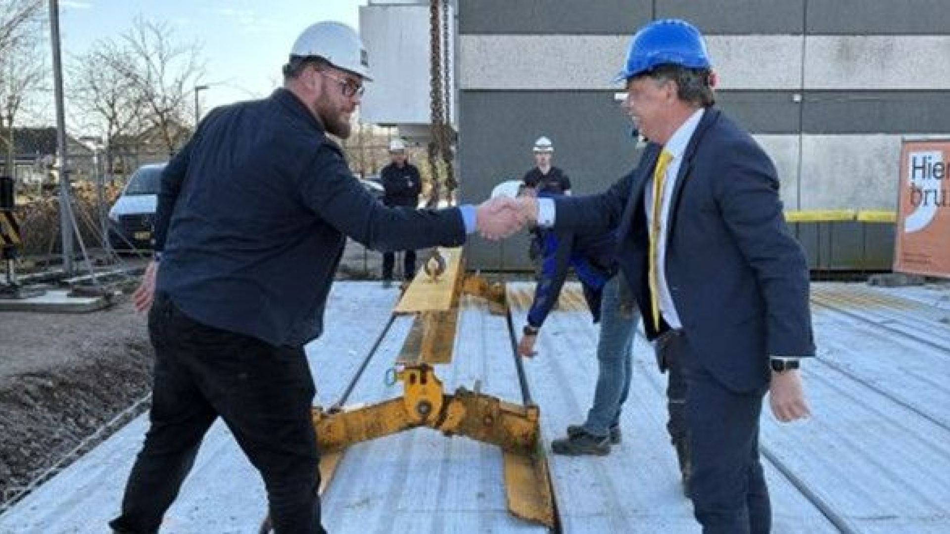 Handdruk na officiële handeling aan de Kloetenseweg, waar 28 huurappartementen en een supermarkt komen.