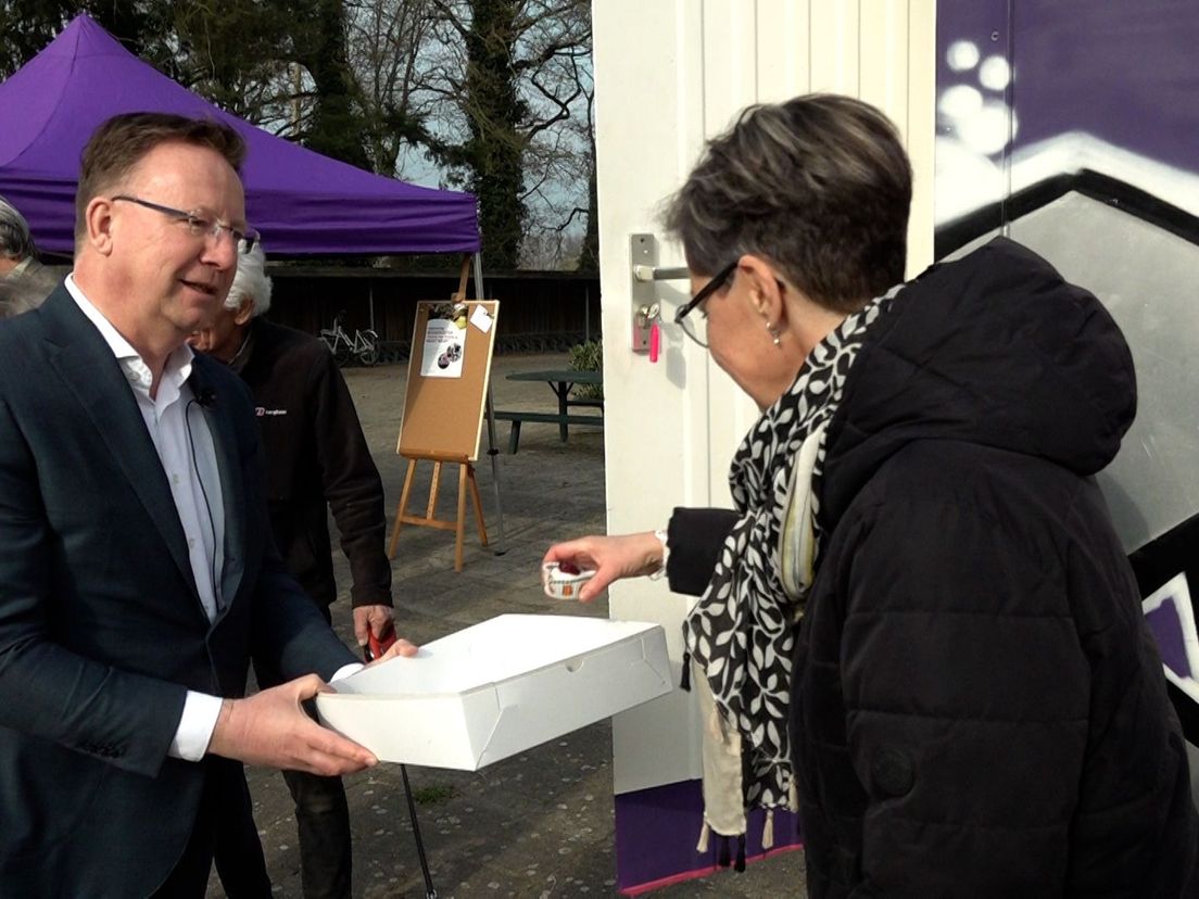 De nieuwe burgemeester deelt kersentaartjes uit in Varssel.