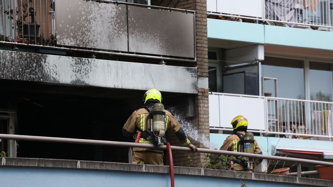 Brandweerlieden verrichten nabluswerkzaamheden bij de woning