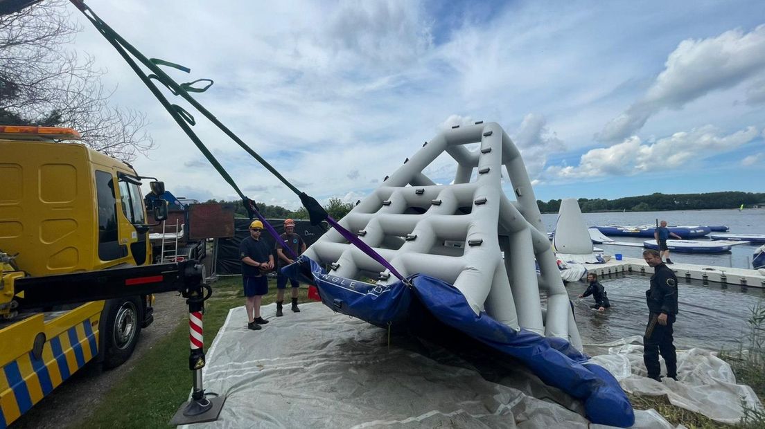 Met een kraanwagen worden de kapotte attracties uit het water gesleept I