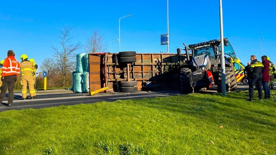 Gekantelde aanhanger met hooibalen blokkeert rotonde.