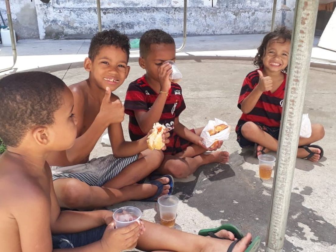 Kinderen uit de fabriekshal in Rio de Janeiro krijgen een lunch