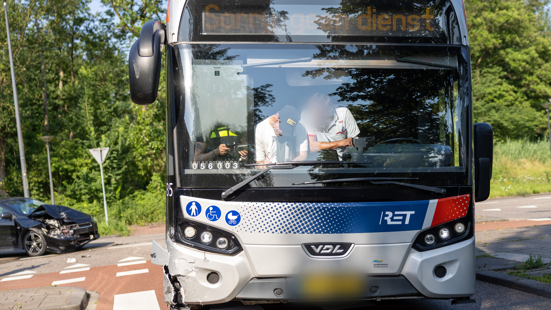 De schade aan de bus en de zwarte auto