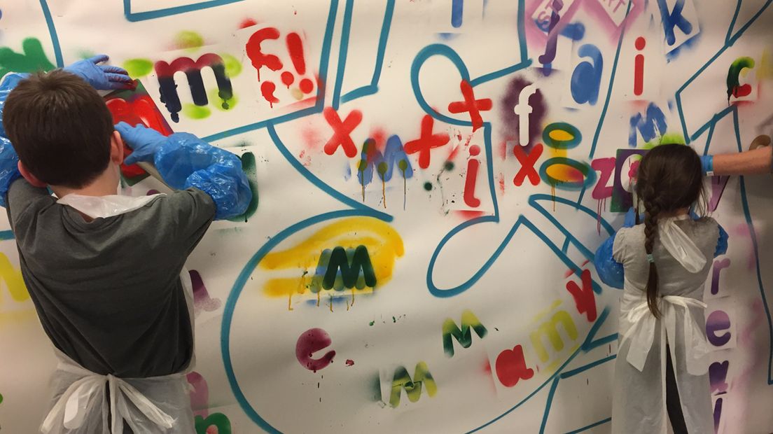 Kinderen aan het werk tijdens cursus streetart