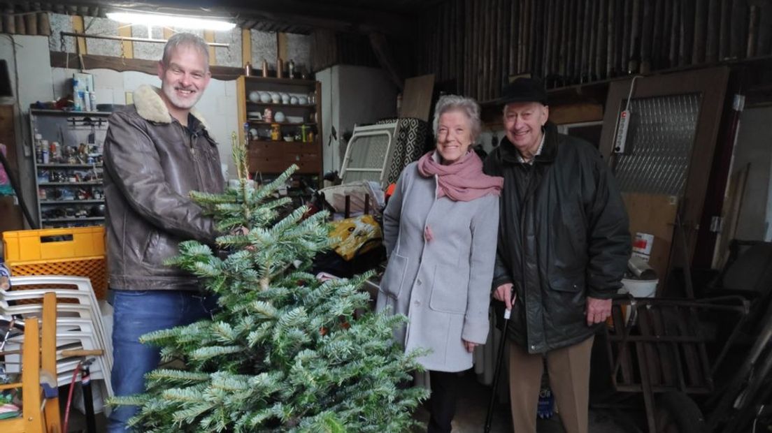 Presentator Eric van den Berg geeft een kerstboom weg.