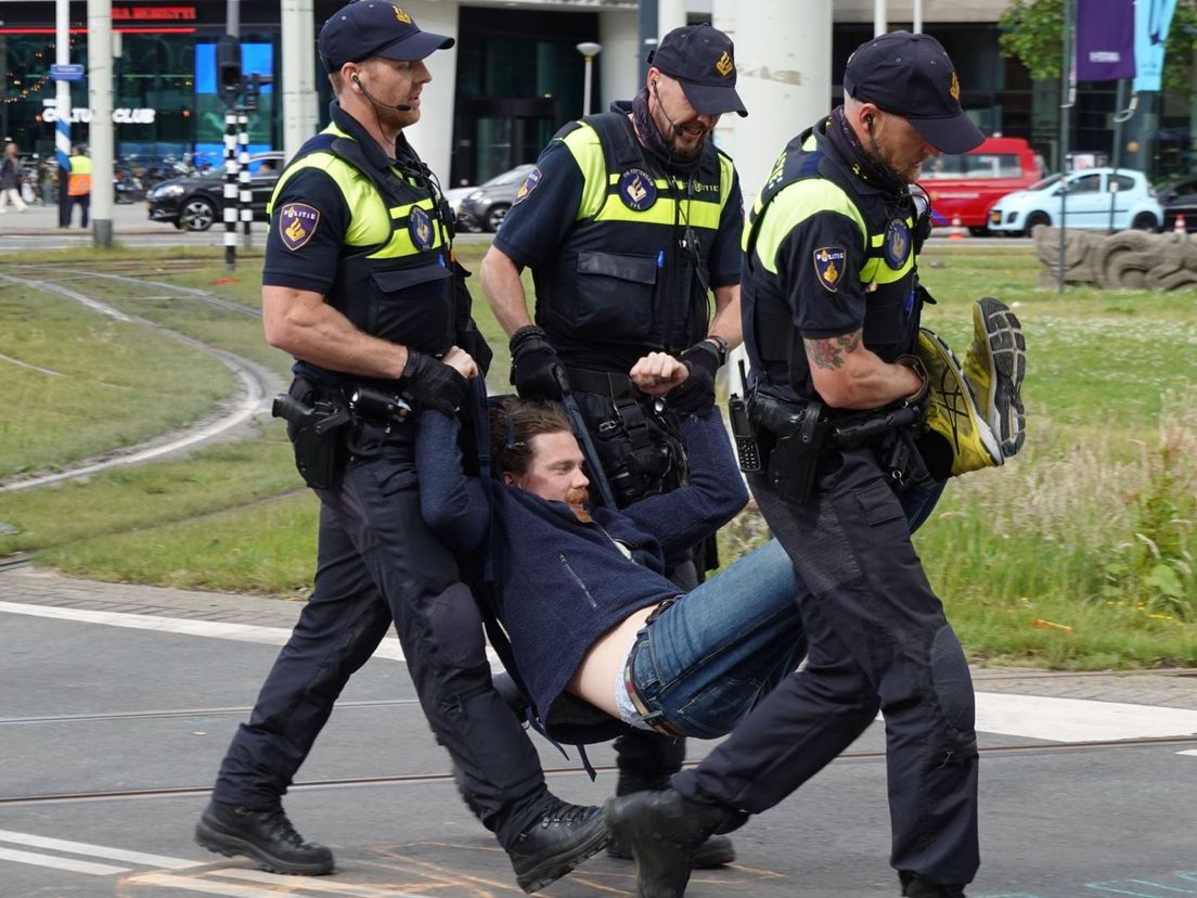 Demonstrant wordt weggedragen door de politie