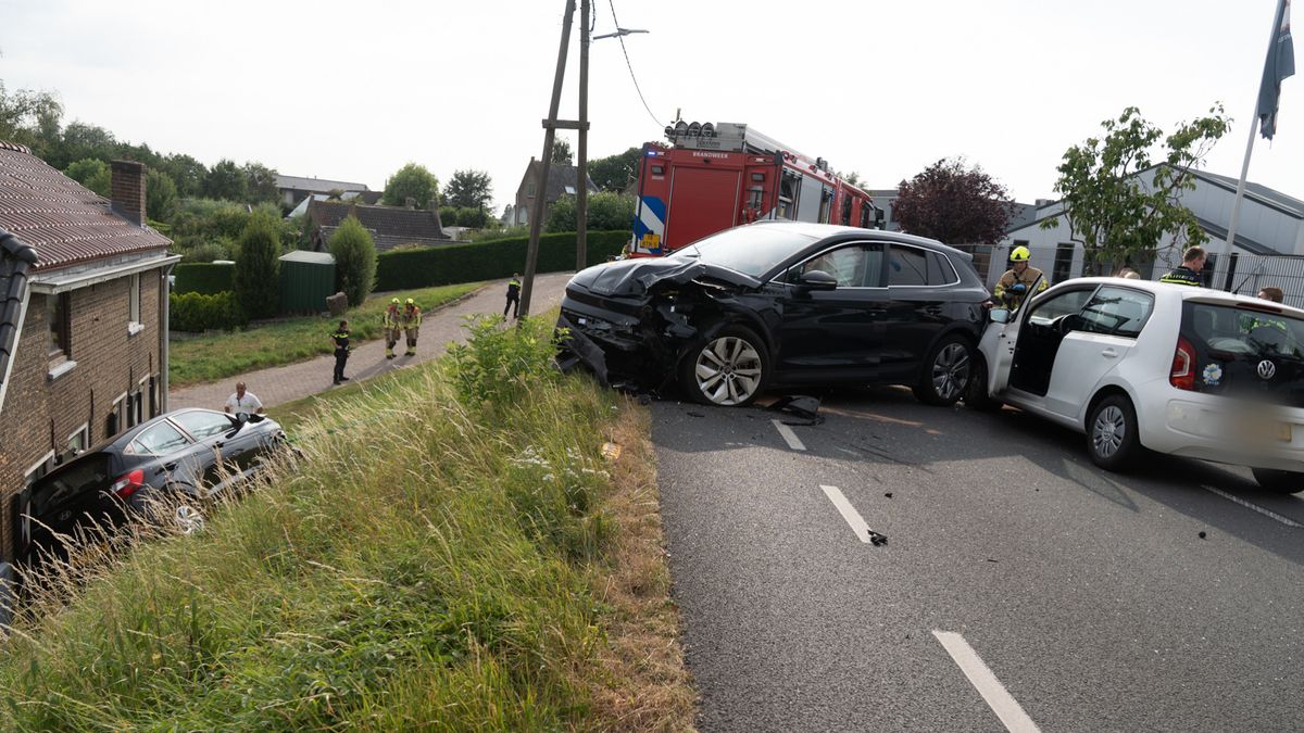 Ongeluk tussen drie auto's, één rolt van dijk af tegen huis aan