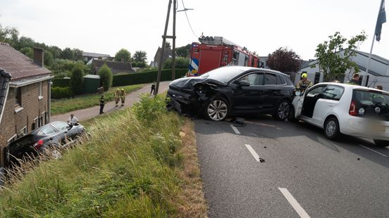 Ongeluk tussen drie auto's, één rolt van dijk af tegen huis aan Home