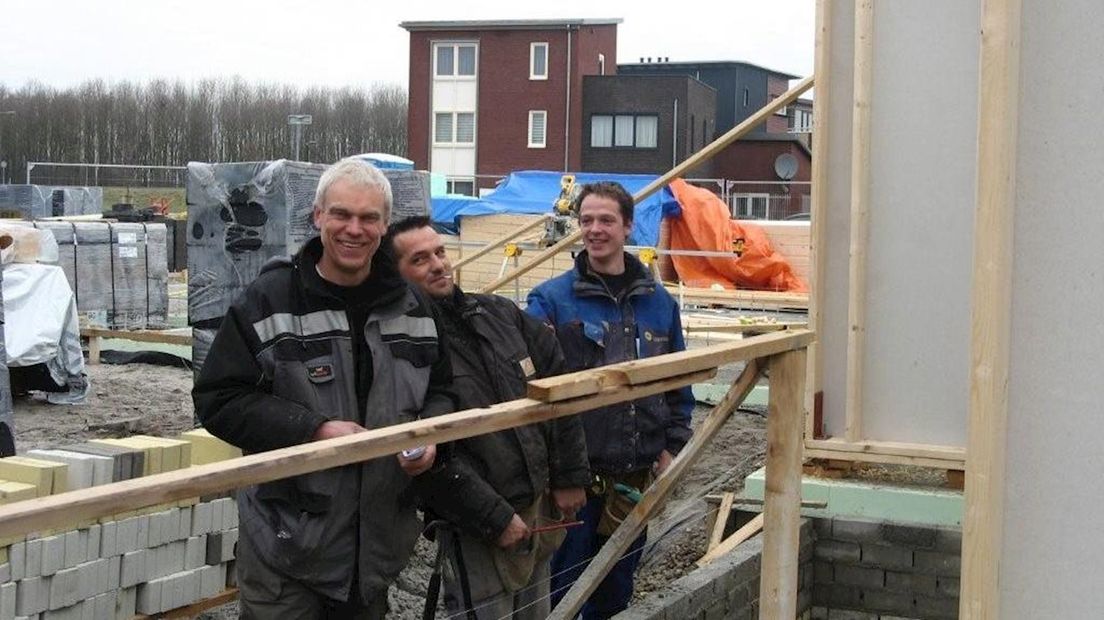 Henk Schuring, links, bij de bouw van de woning van stro