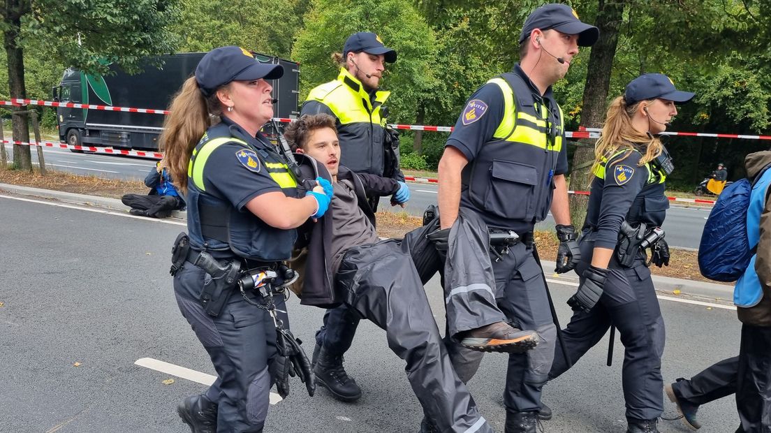 De politie haalt klimaatdemonstranten van de Utrechtsebaan