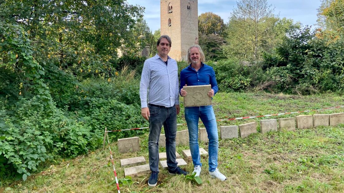 Voorzitter Rogier Rijkers (rechts) en directeur Remco Reiding tonen één van de oude grafstenen bij de plek van het toekomstige museum.