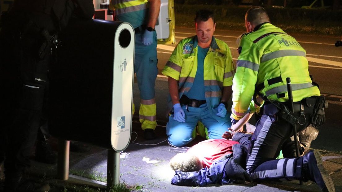 De man die zijn hoofd tegen het raam beukte wordt behandeld door ambulancepersoneel