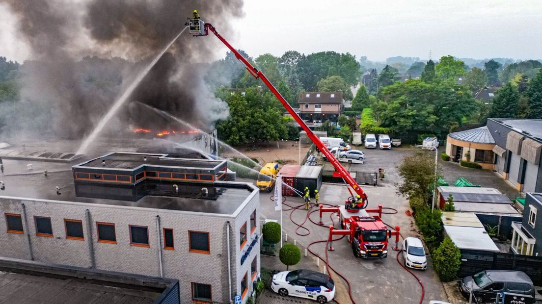 De brandweer is druk doende de vlammen te doven.