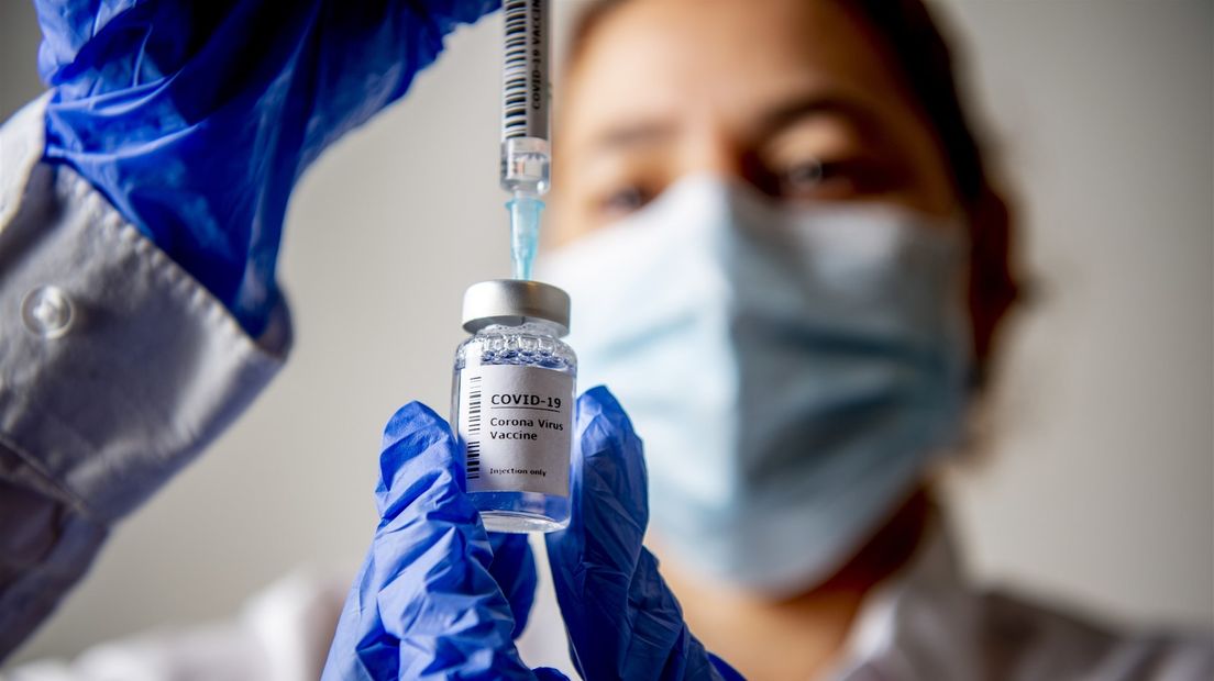 Coronavaccin wordt uit flacon gehaald en gereedgemaakt voor een injectie