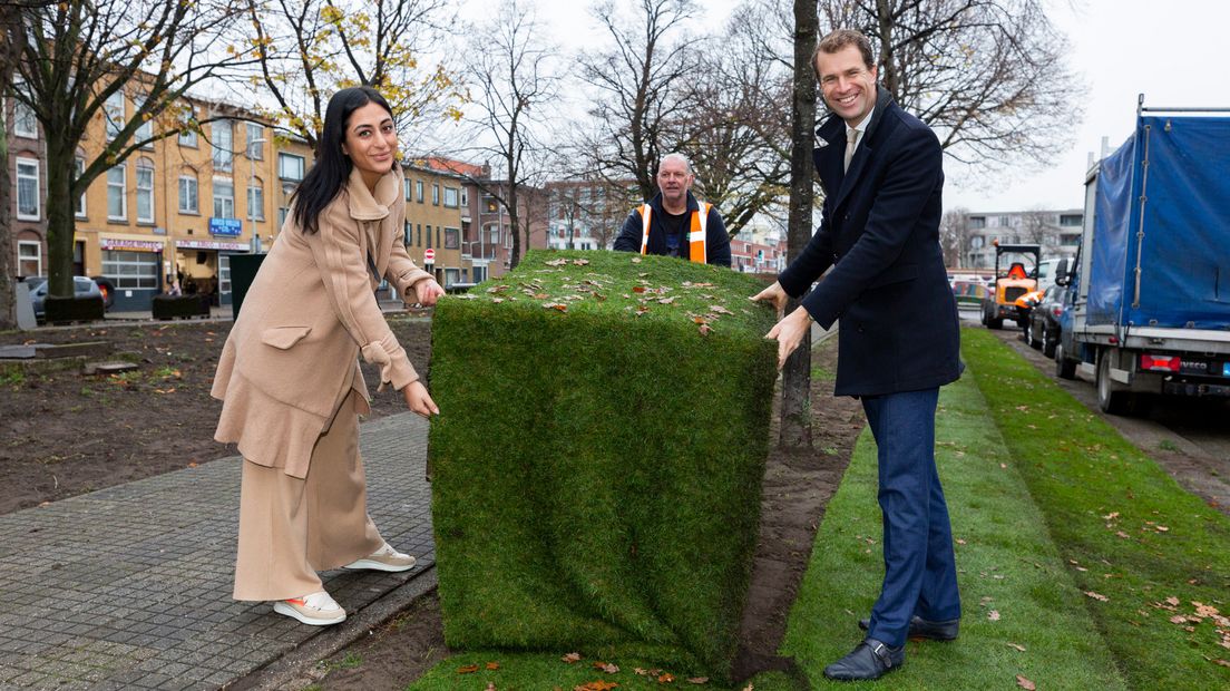 Ebru Akkus en wethouder Hilbert Bredemijer leggen de laatste graszode voor een hondenveldje aan de Delftselaan