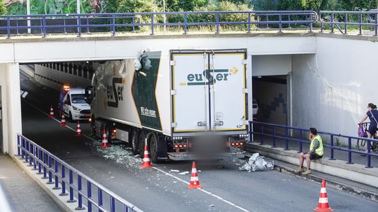 Te hoge vrachtwagen met tompoucen en roerbakgroente rijdt zich vast in tunnel