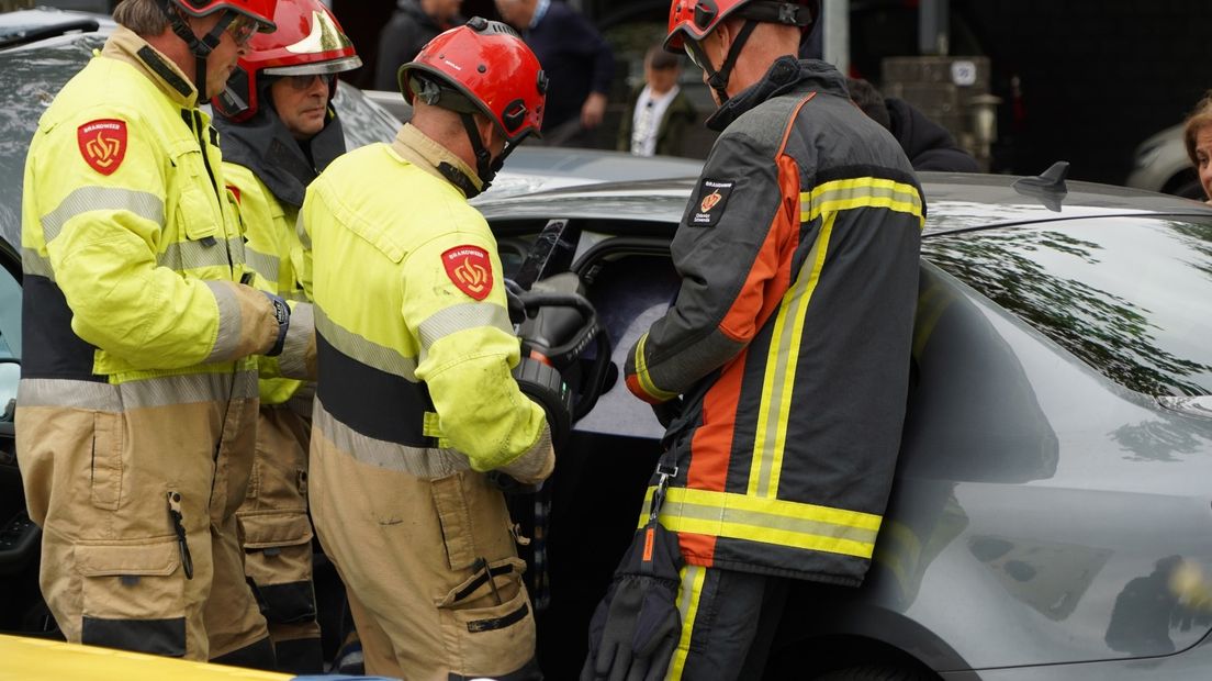Brandweermannen halen de persoon uit de auto