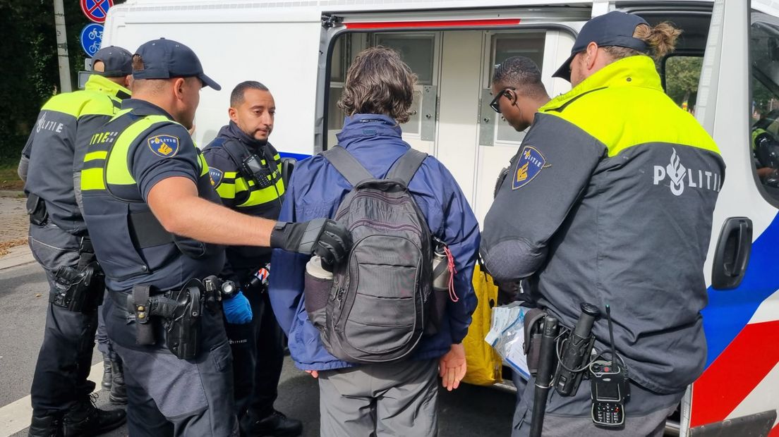 Een klimaatactivist wordt door de politie gearresteerd
