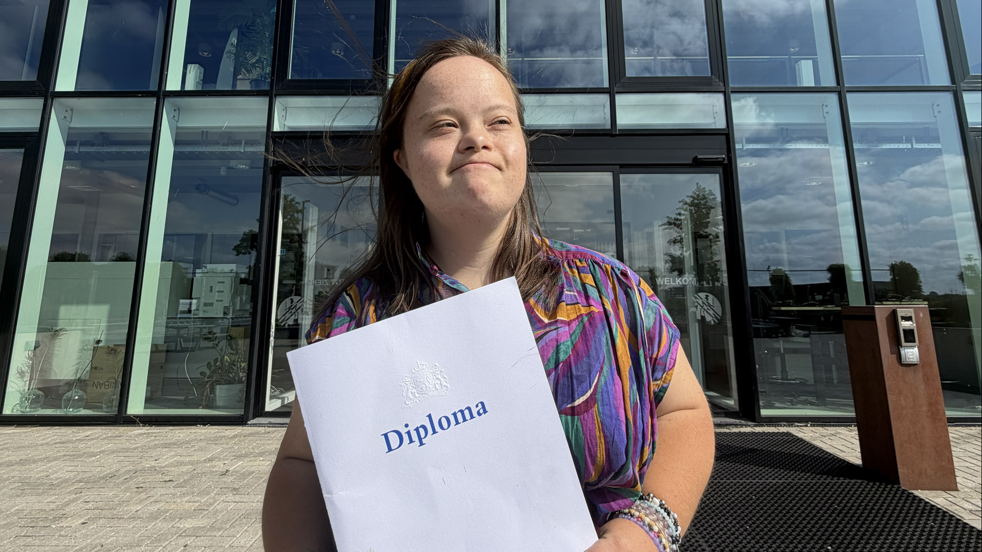 Sterre poseert trots met haar diploma voor het Wolfert Lansing