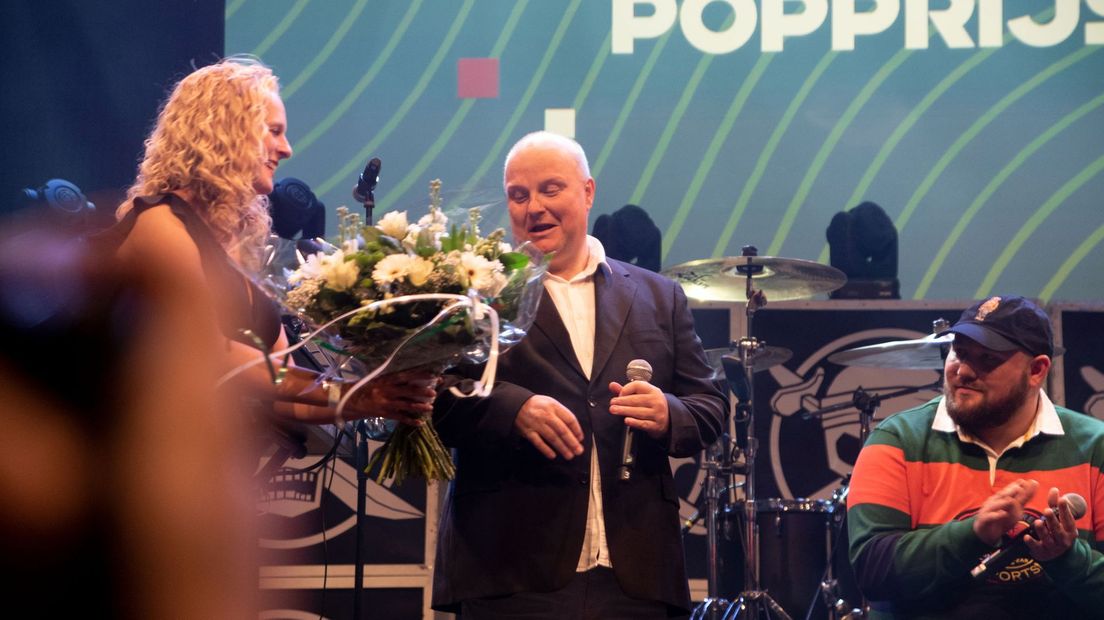 De manager van Rowwen Hèze neemt de Popprijs in ontvangst. 