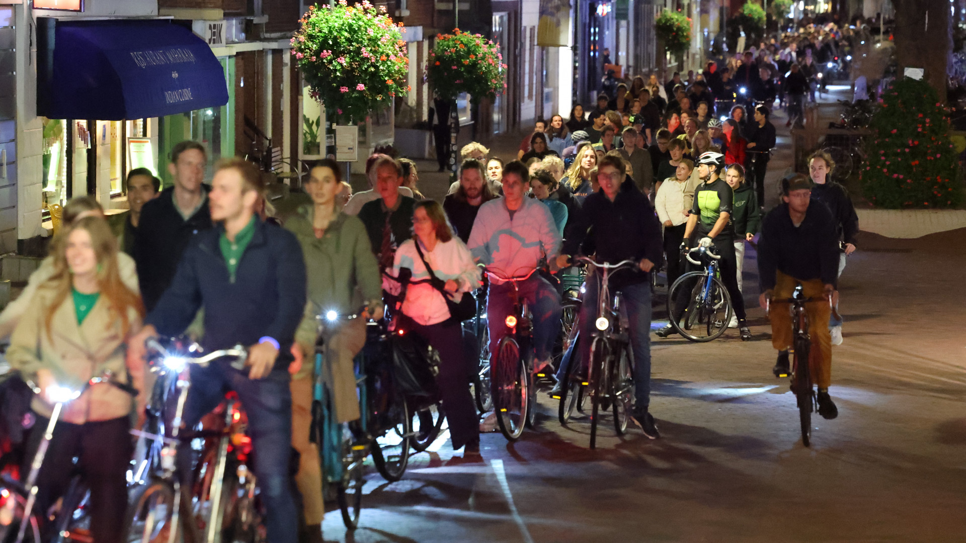 Een lange rij fietsers gaat op weg naar Delftse Hout