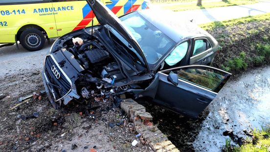 Auto rijdt tegen de muur van een brug