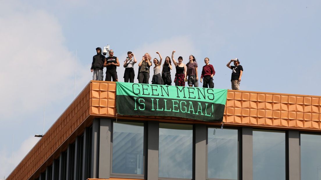 Actievoerders op het dak van het gebouw aan de Oude Waalsdorperweg.