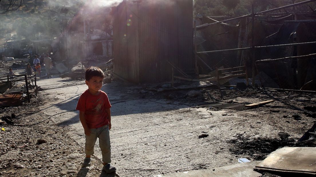 Een kind loopt door de puinhopen na de verwoestende brand in het Moria-vluchtelingenkamp