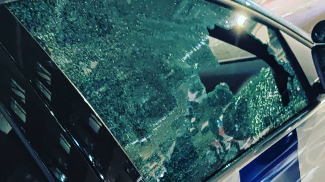Een relschopper gooide een steen door de ruit van een politieauto.