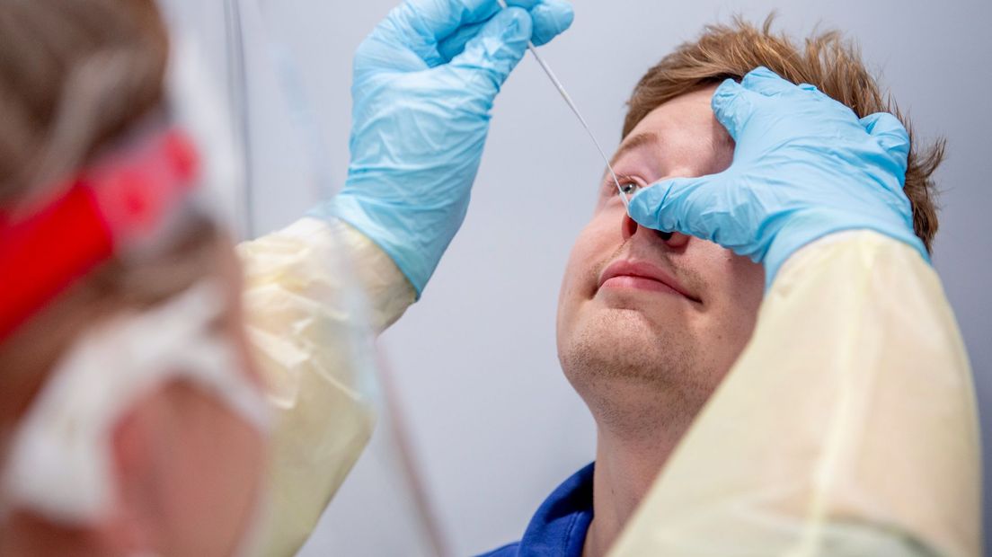 Een jongen wordt getest in coronateststraat van GGD