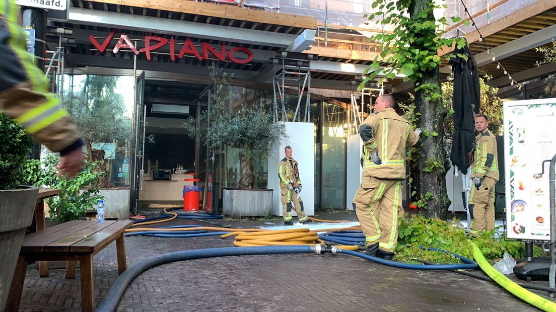 Brandweerlieden bij het grote leegstaande pand van het restaurant Vapiano op het Buitenhof