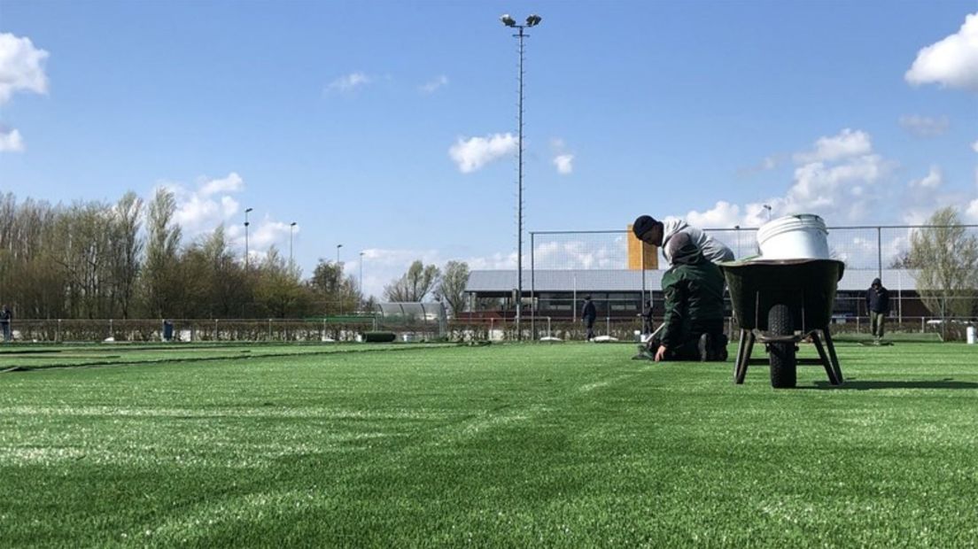 De aanleg van het kunstgrasveld zonder rubberkorrels op sportcomplex Kardinge