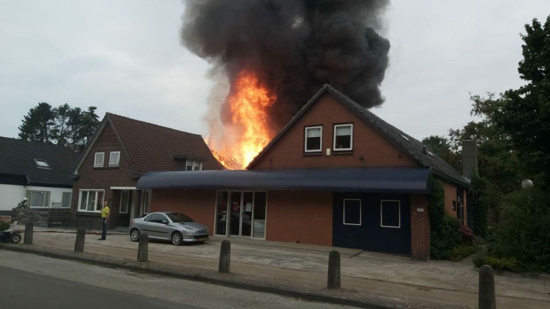 De vlammen stijgen hoog boven de loods in Valthermond uit.