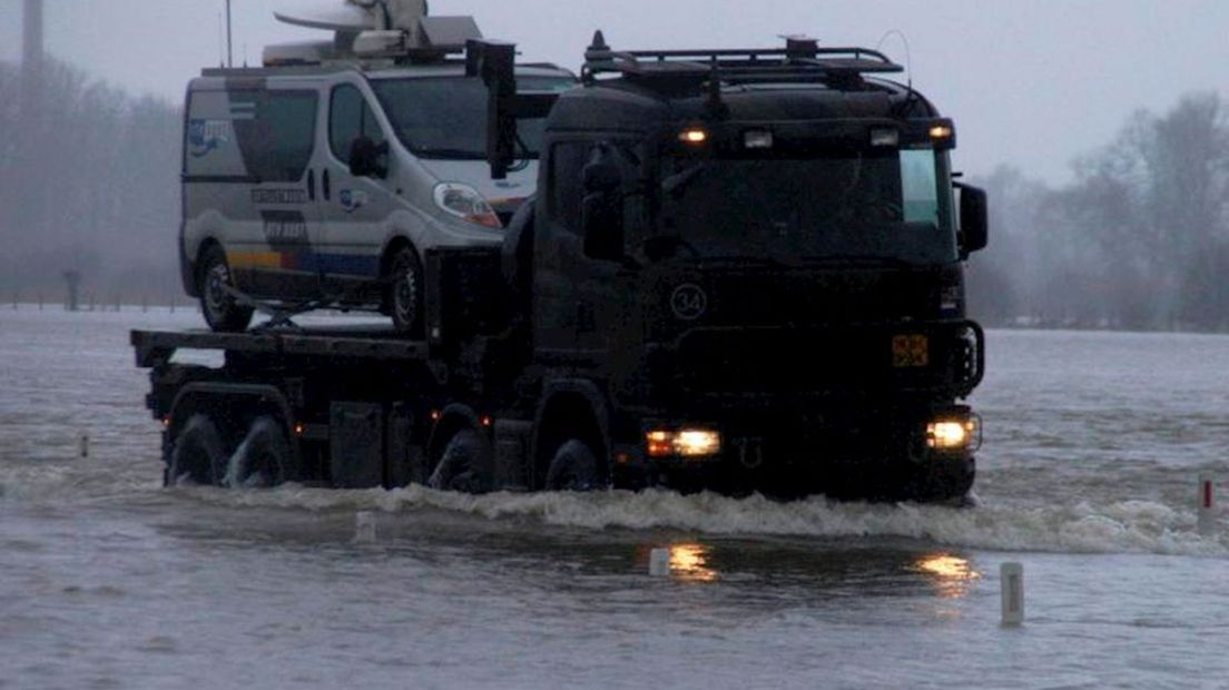 De wagen van RTV Oost wordt door het leger naar het droge gebracht.
