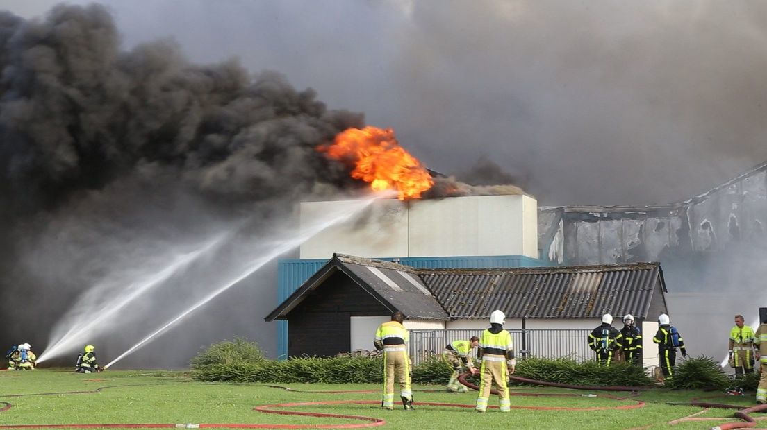 Brandweermensen aan het werk bij stalbrand