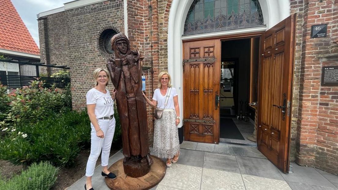 De nieuwe eigenaren met het beeld voor de kerk