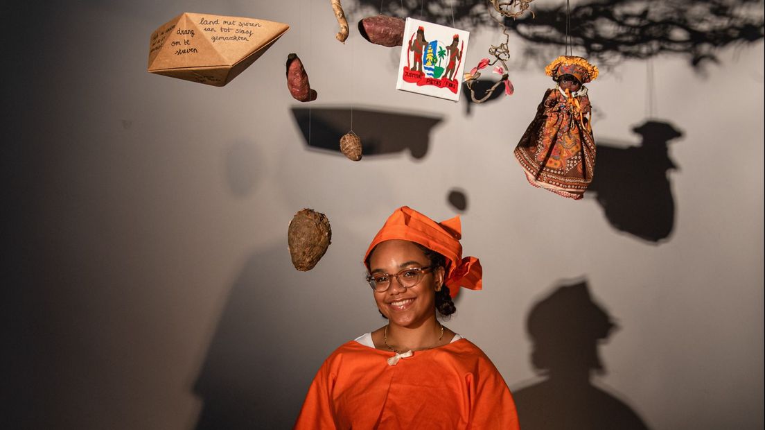Elisa poserend bij de 'Surinameboom', een kunstinstallatie met Surinaamse objecten en gedichten.