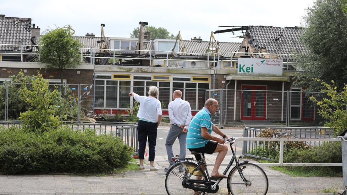 Een dag na de brand bekijken buurtbewoners de schade