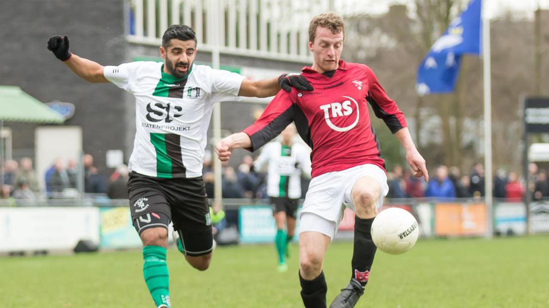 Scheveningen-speler Mehmet Aldogan in duel met Rob Zandbergen van FC Rijnvogels 