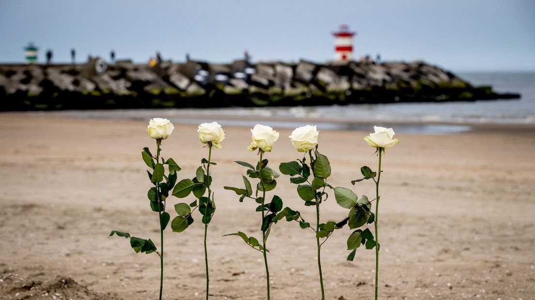 Vijf rozen op het strand ter nagedachtenis aan de vijf omgekomen mannen