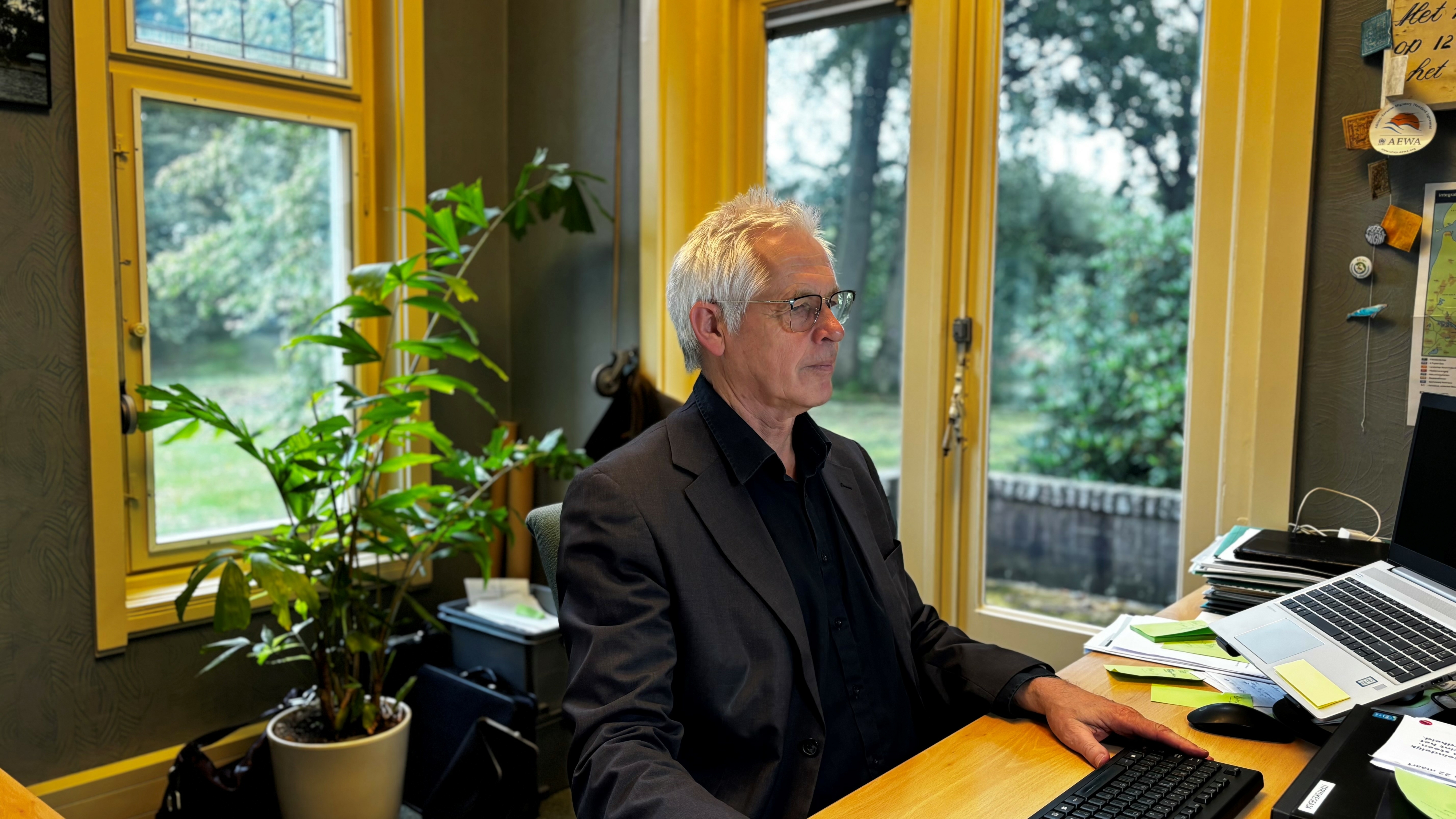 Henk de Vries achter de pc yn syn kantoar